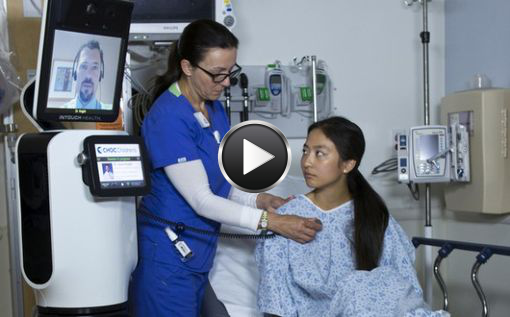 Un médecin ausculte une patiente par l'intermédiaire de RP-VITA et d'une infirmière qui tient le stéthoscope