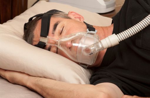 Patient présentant des apnées du sommeil et dormant avec un dispositif à PPC (illustration).